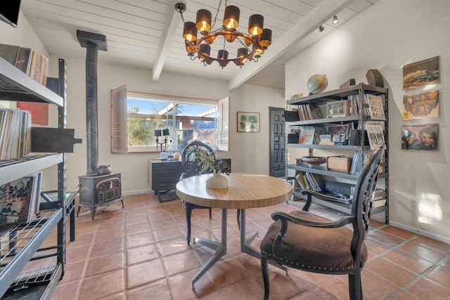 tiled dining space featuring a wood stove, beamed ceiling, wooden ceiling, and rail lighting