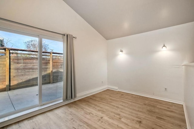 unfurnished room with baseboards, vaulted ceiling, and wood finished floors