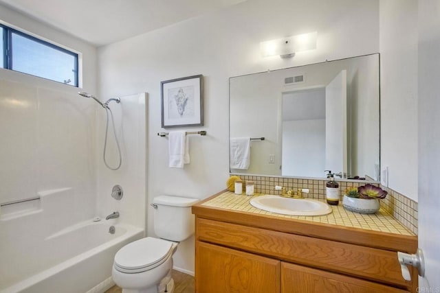 bathroom featuring visible vents, toilet, vanity, washtub / shower combination, and backsplash