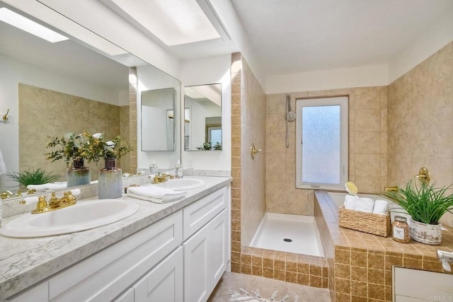 bathroom featuring double vanity, a skylight, a sink, and tiled shower