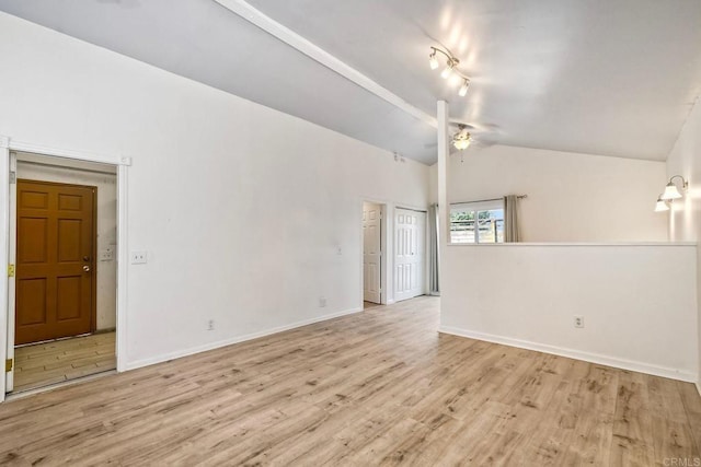 unfurnished room featuring light wood-style floors, vaulted ceiling with beams, baseboards, and a ceiling fan