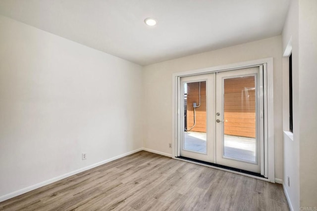 empty room featuring light wood-type flooring, recessed lighting, baseboards, and french doors