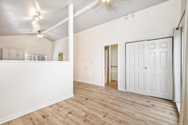 interior space featuring lofted ceiling, a closet, baseboards, and light wood finished floors