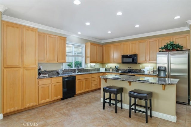 kitchen with sink, black appliances, a breakfast bar area, and a kitchen island