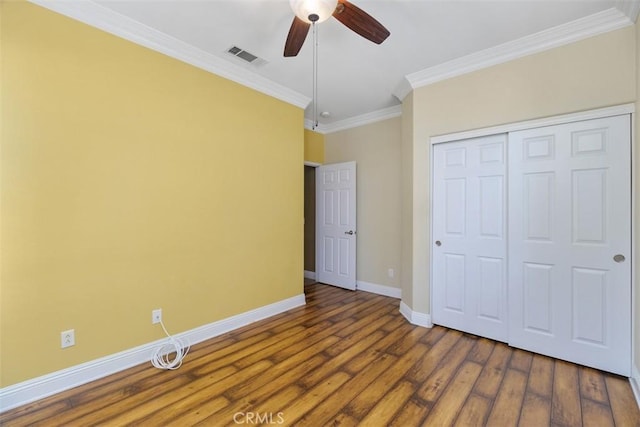 unfurnished bedroom with ceiling fan, a closet, crown molding, and dark hardwood / wood-style flooring