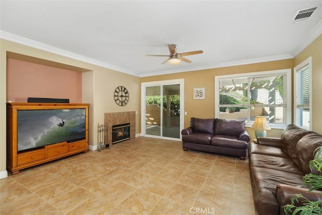 living room with crown molding, a premium fireplace, and ceiling fan