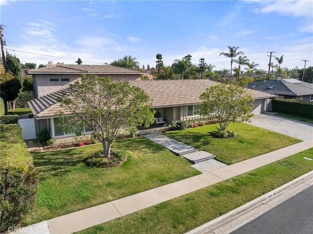 view of front of property with a front yard and a garage