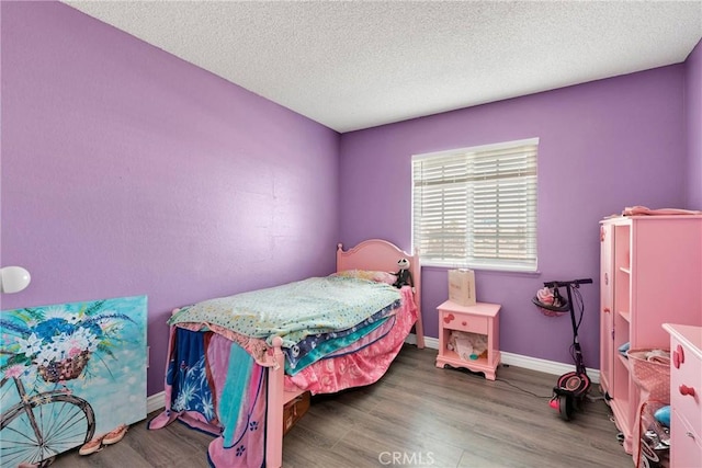 bedroom featuring baseboards, a textured ceiling, and dark wood-type flooring