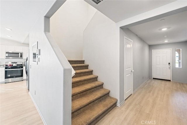 foyer entrance with visible vents, baseboards, stairway, light wood-type flooring, and recessed lighting