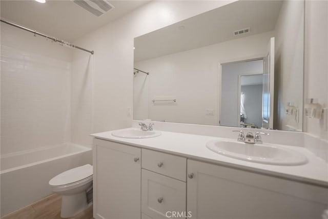 full bathroom featuring a sink, visible vents, toilet, and double vanity