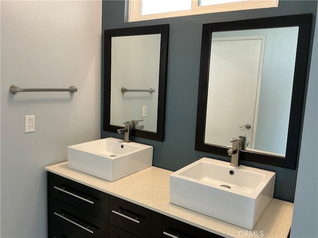 full bathroom with double vanity and a sink