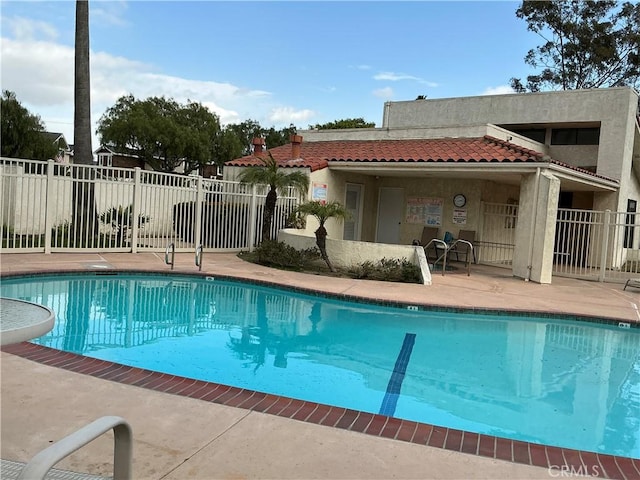 community pool featuring a patio and fence