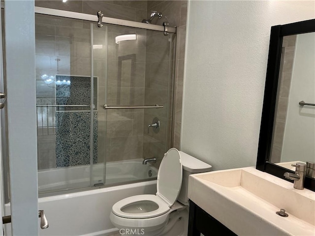 full bath with enclosed tub / shower combo, toilet, vanity, and a textured wall