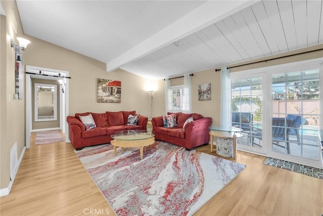 living room with hardwood / wood-style floors, a barn door, and lofted ceiling with beams