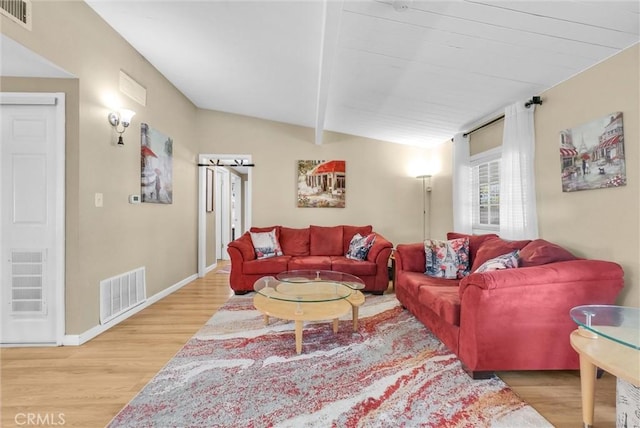 living room with light wood-type flooring and vaulted ceiling with beams