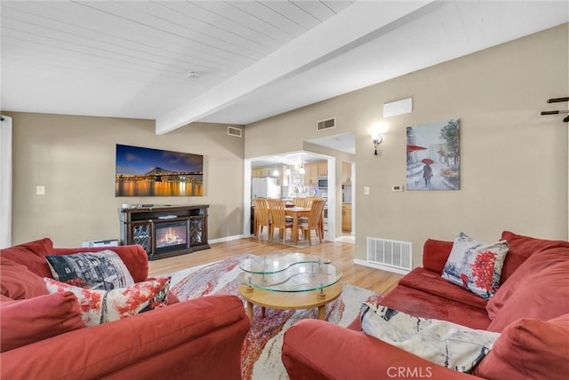 living room with lofted ceiling with beams and wood-type flooring