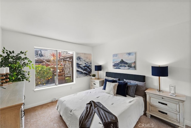 bedroom with light carpet and baseboards