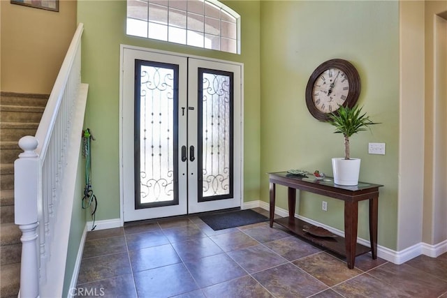 entryway featuring dark tile patterned flooring and french doors