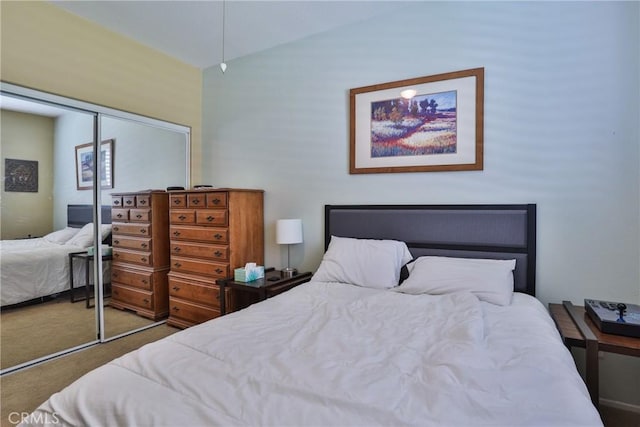 carpeted bedroom featuring a closet and vaulted ceiling