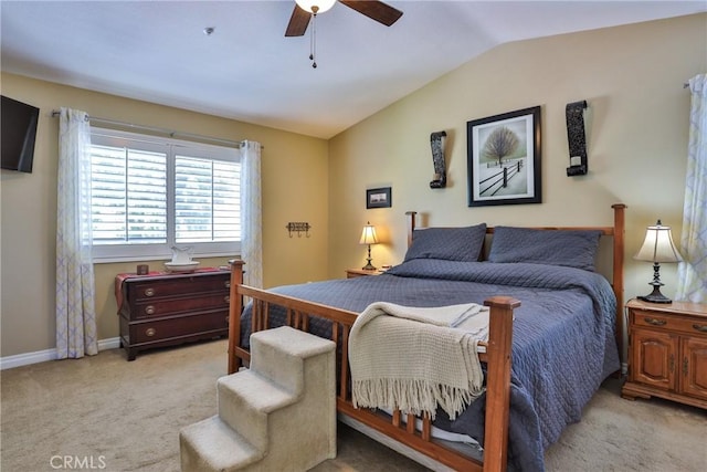 carpeted bedroom with ceiling fan and vaulted ceiling