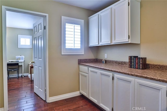 kitchen featuring dark wood-type flooring and white cabinets