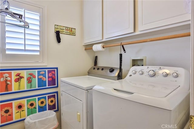 washroom with washer and dryer and cabinets