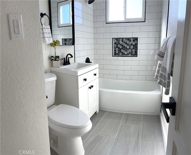 bathroom with a textured wall, vanity, and toilet