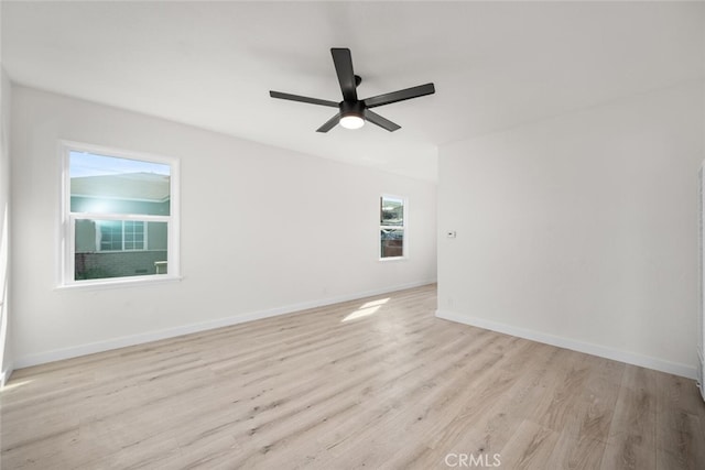 empty room featuring light wood finished floors, ceiling fan, and baseboards