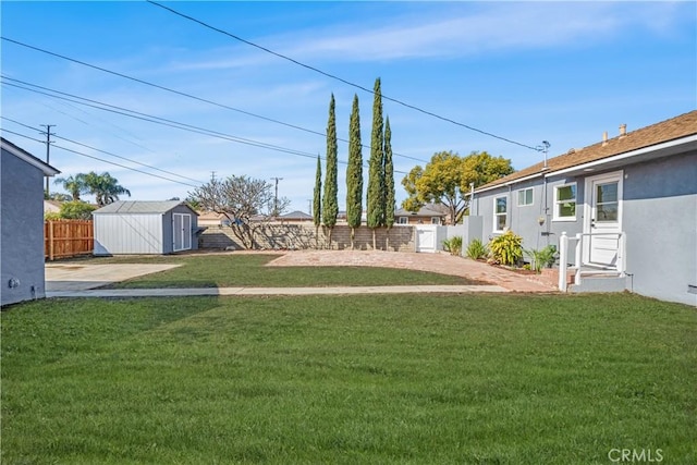 view of yard featuring a fenced backyard, a storage unit, and an outbuilding