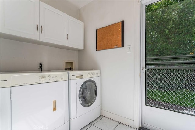 clothes washing area with independent washer and dryer, light tile patterned floors, and cabinets