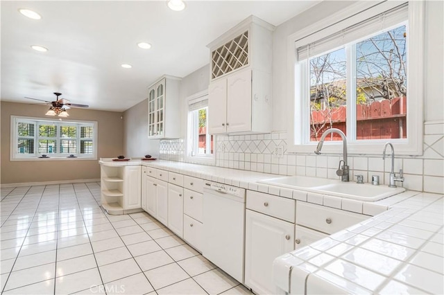 kitchen featuring white cabinets, tile counters, and white dishwasher