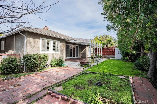 back of house featuring a pergola, a lawn, and a patio area