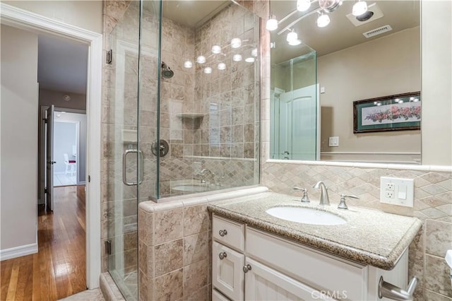 bathroom with vanity, a shower with door, and hardwood / wood-style floors