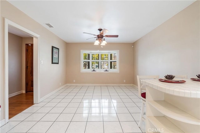 tiled empty room with ceiling fan