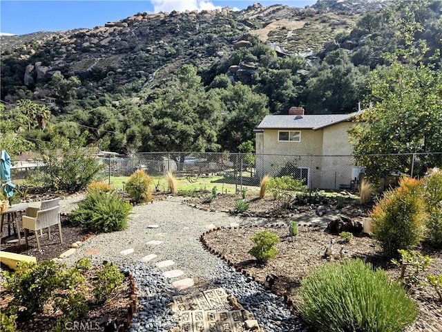 view of yard featuring a mountain view and fence