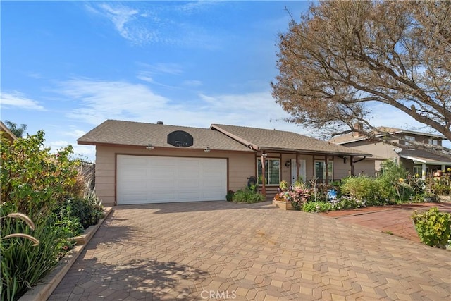 ranch-style house with a garage and decorative driveway