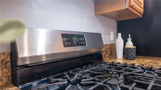 room details with stone countertops and stainless steel gas stove