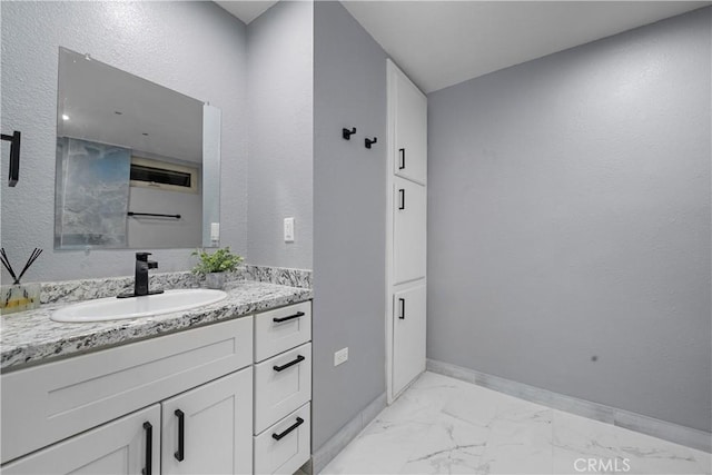 bathroom featuring marble finish floor, baseboards, and vanity