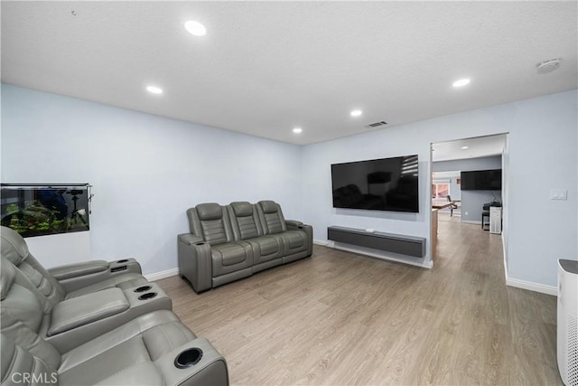 living area with baseboards, light wood-style flooring, visible vents, and recessed lighting