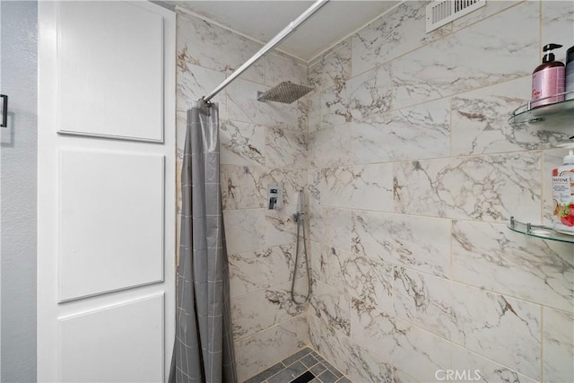 full bathroom with a shower stall and visible vents