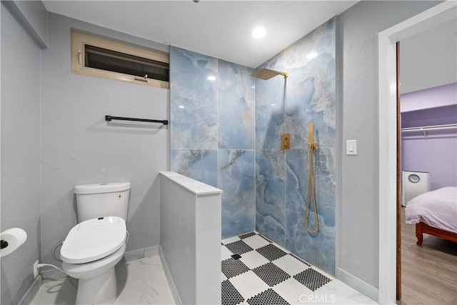 ensuite bathroom featuring baseboards, toilet, ensuite bathroom, marble finish floor, and a walk in shower