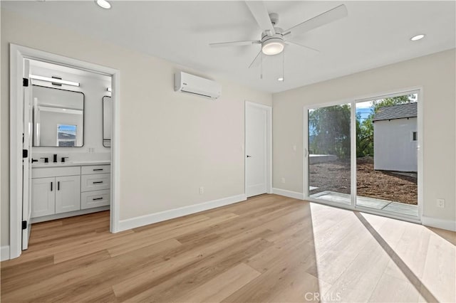 unfurnished bedroom featuring access to exterior, baseboards, light wood-style floors, and an AC wall unit