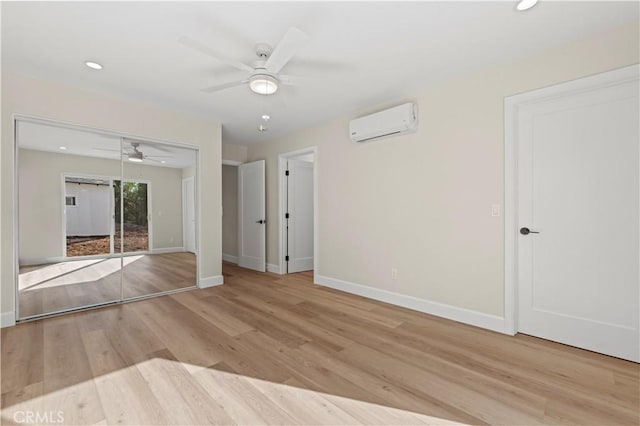 empty room with baseboards, ceiling fan, an AC wall unit, light wood-type flooring, and recessed lighting