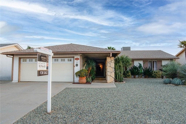 ranch-style home featuring concrete driveway and a garage