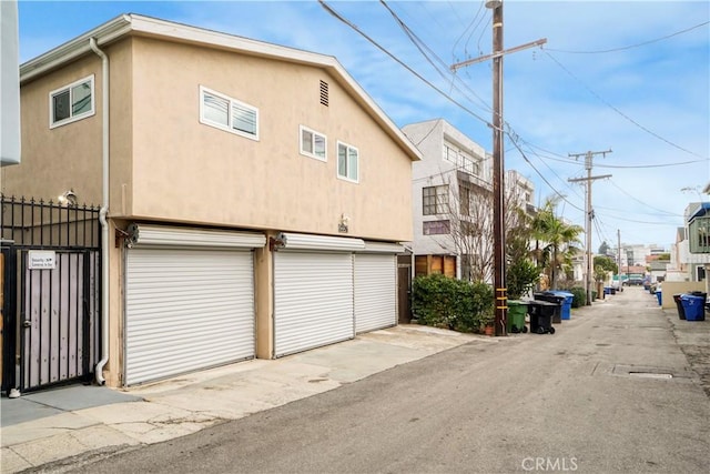 exterior space with stucco siding, fence, and an attached garage