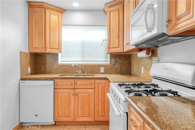 kitchen with white appliances, light brown cabinetry, decorative backsplash, a sink, and light tile patterned flooring