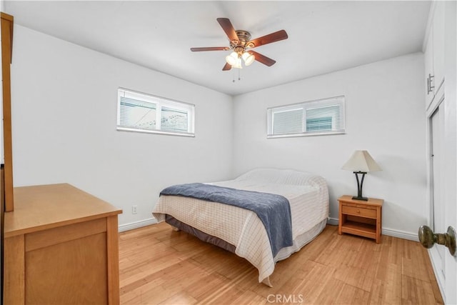 bedroom featuring light wood-style flooring, baseboards, and ceiling fan