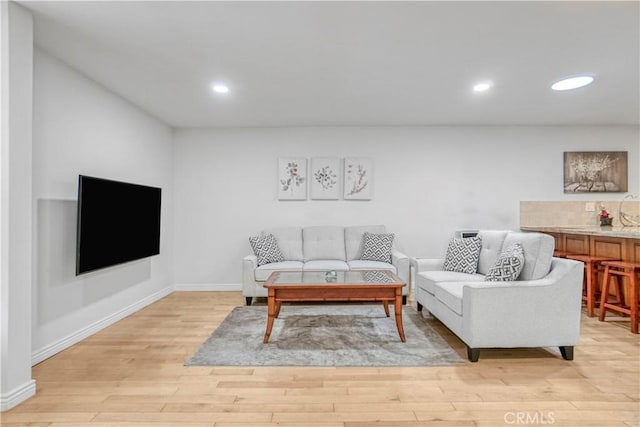 living room with recessed lighting, light wood-style flooring, and baseboards