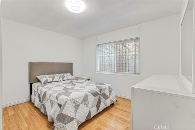 bedroom featuring baseboards and light wood-type flooring