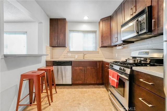 kitchen featuring plenty of natural light, appliances with stainless steel finishes, light countertops, and a sink